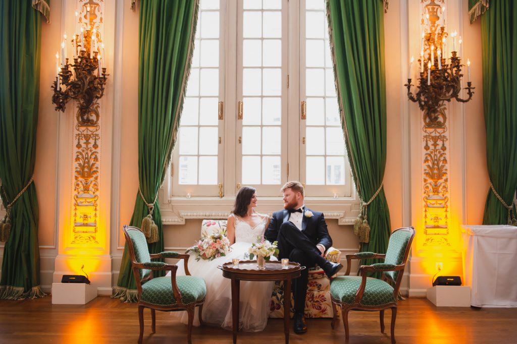 Couple pose in front of green curtains at Sulgrave Club in Washington DC