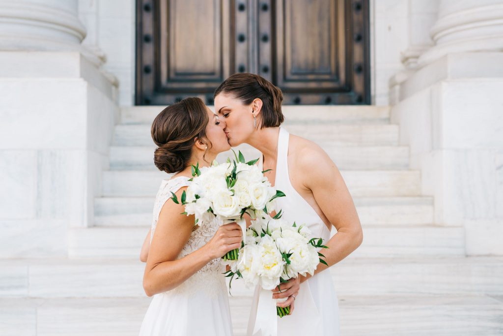 Brides share kiss on steps of Daughters of the American Revolution on wedding day